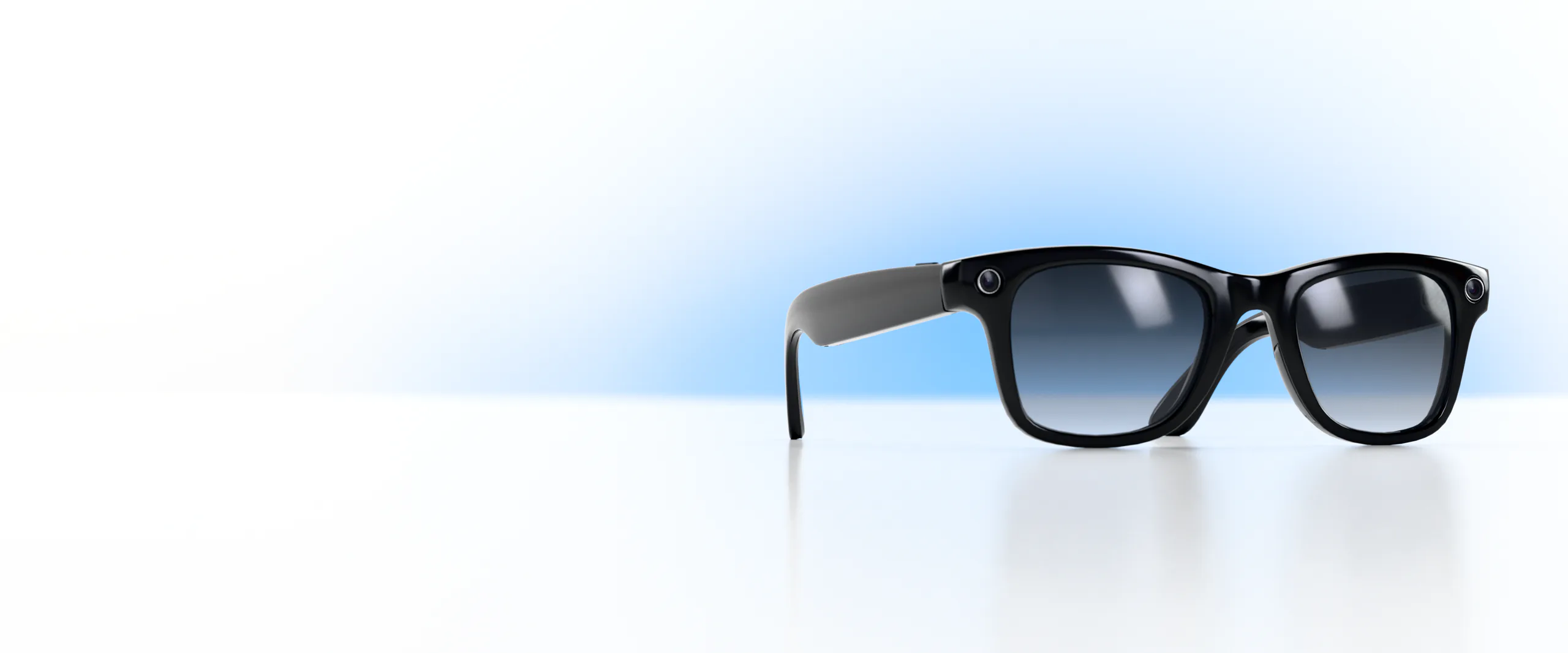 Ray-Ban Meta smart glasses on a floor, lit blue from behind
